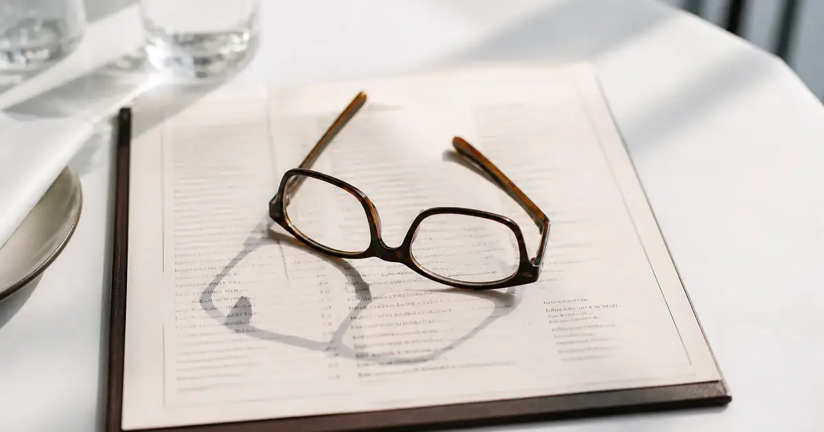 Reading glasses on a printed menu in daylight
